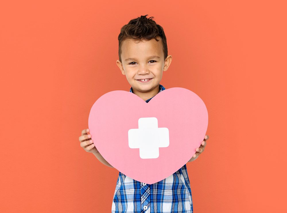 Boy holding a heart with a white cross
