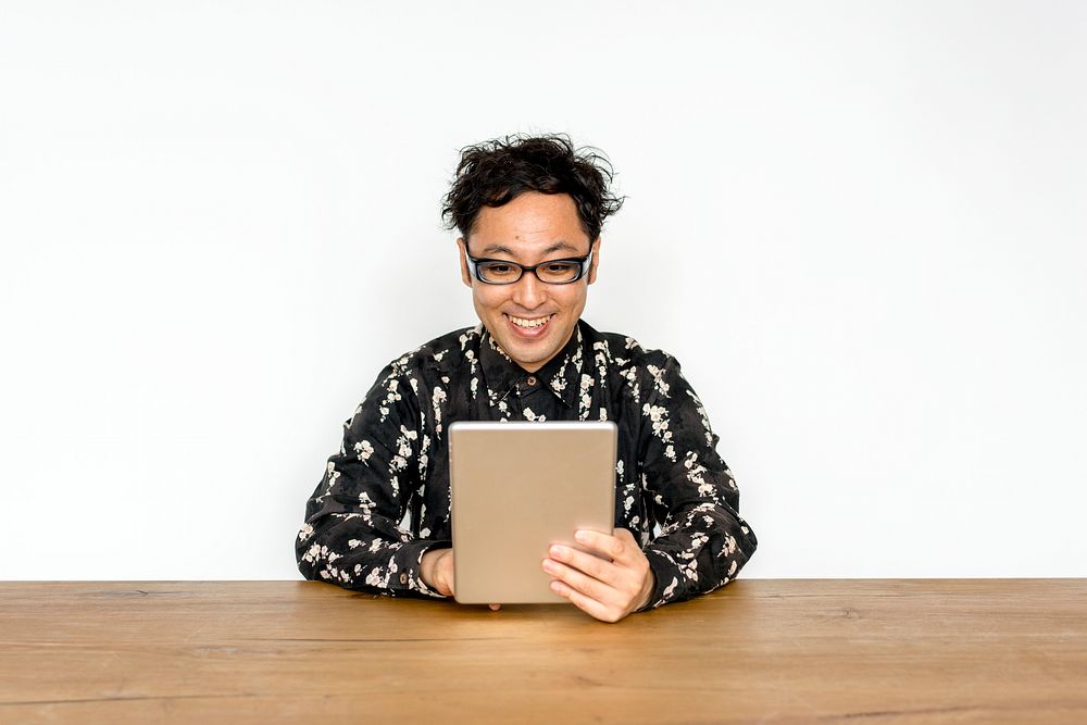 Asian guy with eyeglasses using digital tablet