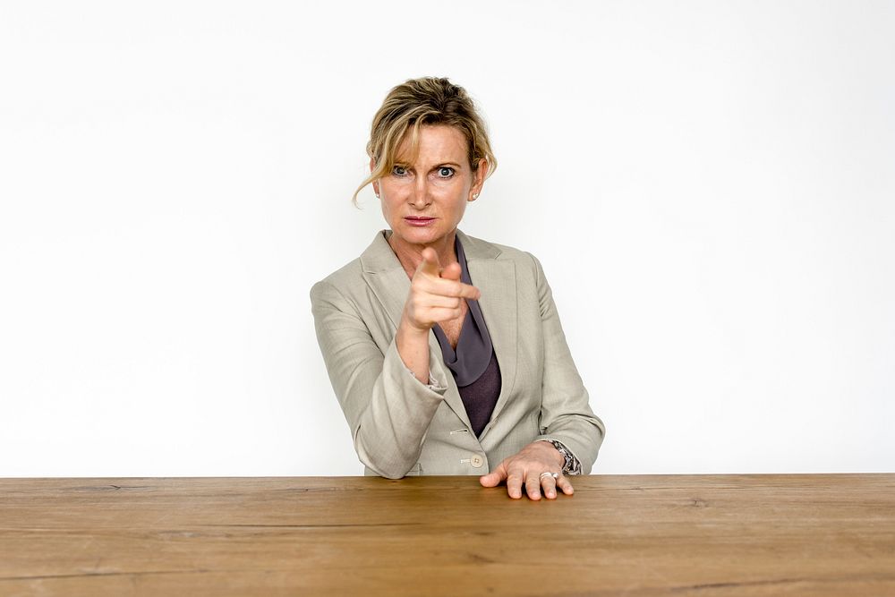 Portrait of an angry business woman pointing at the camera
