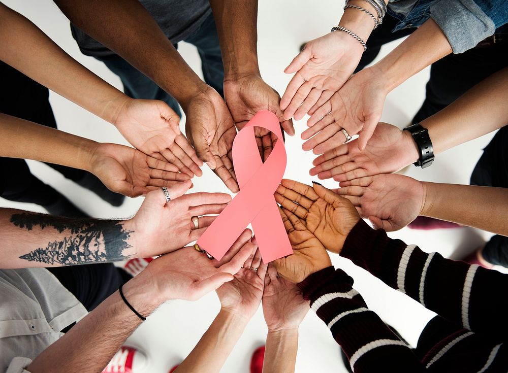 People holding a Brest Cancer Awareness ribbon