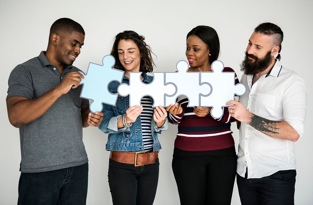 Group of People Holding Puzzle Pieces Concept
