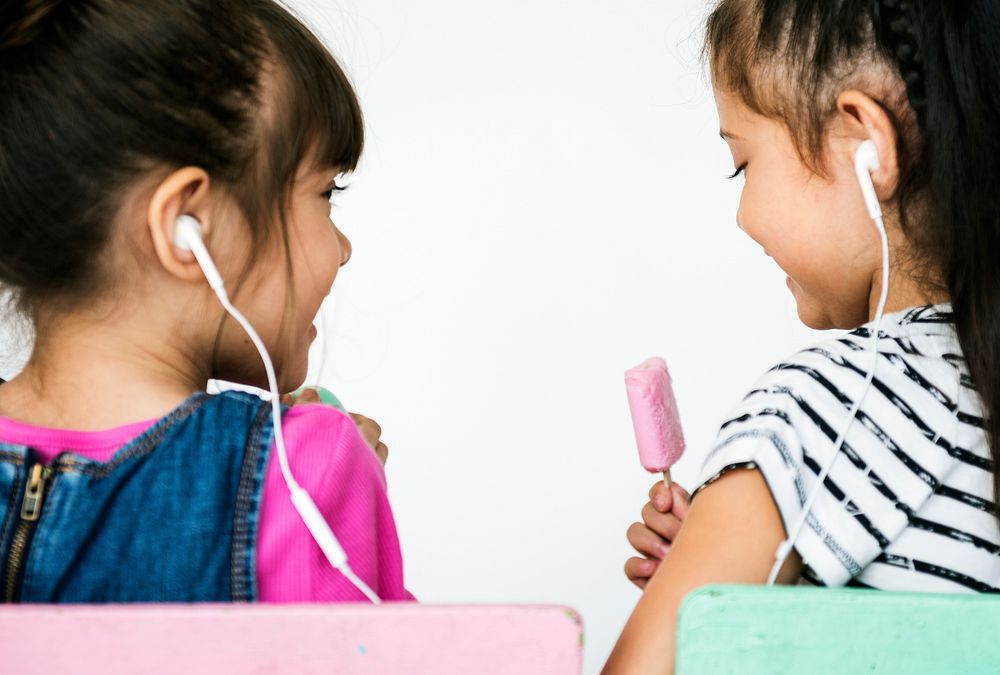Two little girls listening to music