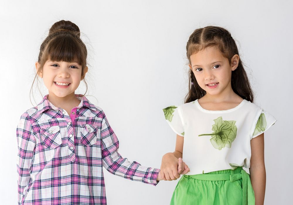 Little cute and adorable girls smiling together studio portrait