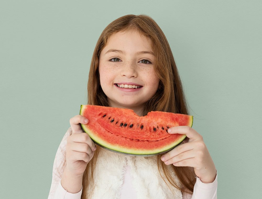 Young cheerful girl holding a slice of watermelon