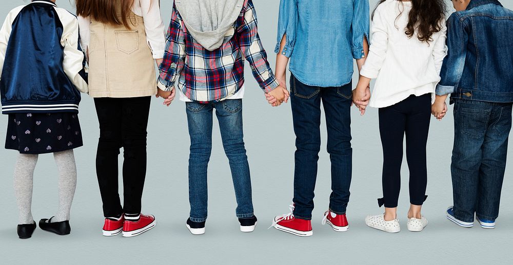 Group of diverse kids students standing in a row holdings hands