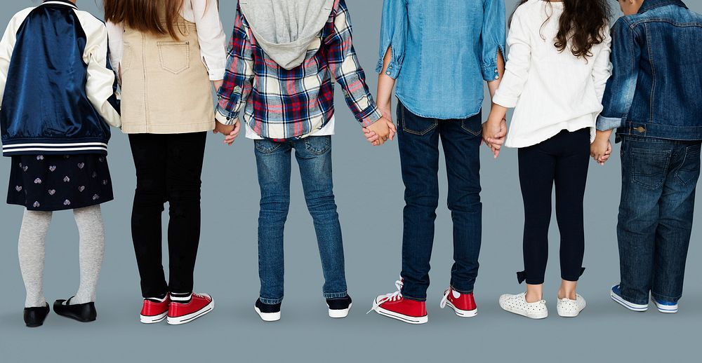 Group of diverse kids students standing in a row holdings hands