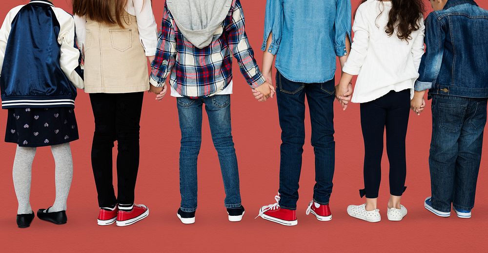 Group of diverse kids students standing in a row holdings hands