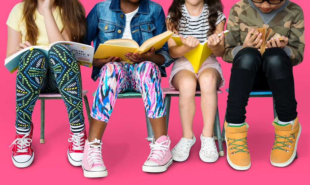 Diverse group of kids sitting in a row reading books