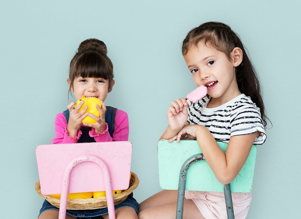 Two young girls sitting on a chair portrait