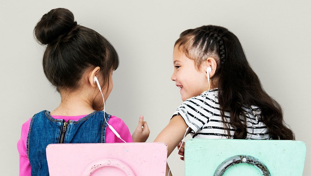 Rear view of two girls listening to music