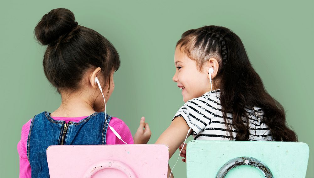 Rear view of two girls listening to music