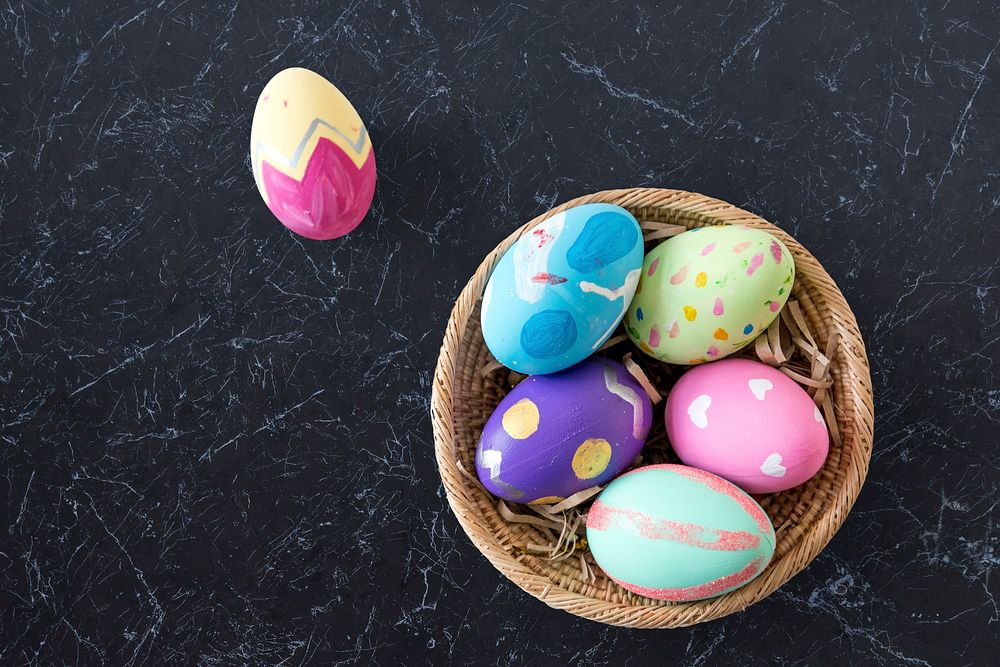 A variety easter painted eggs is in bucket.