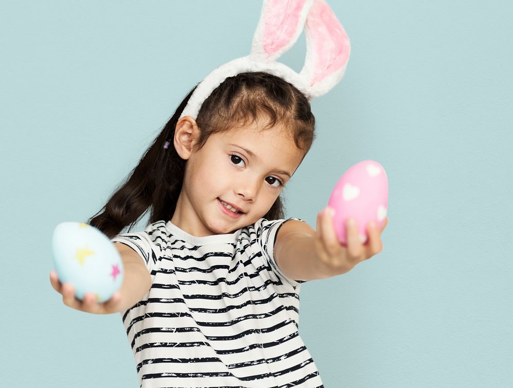 A girl with an easter eggs and bunny hairband