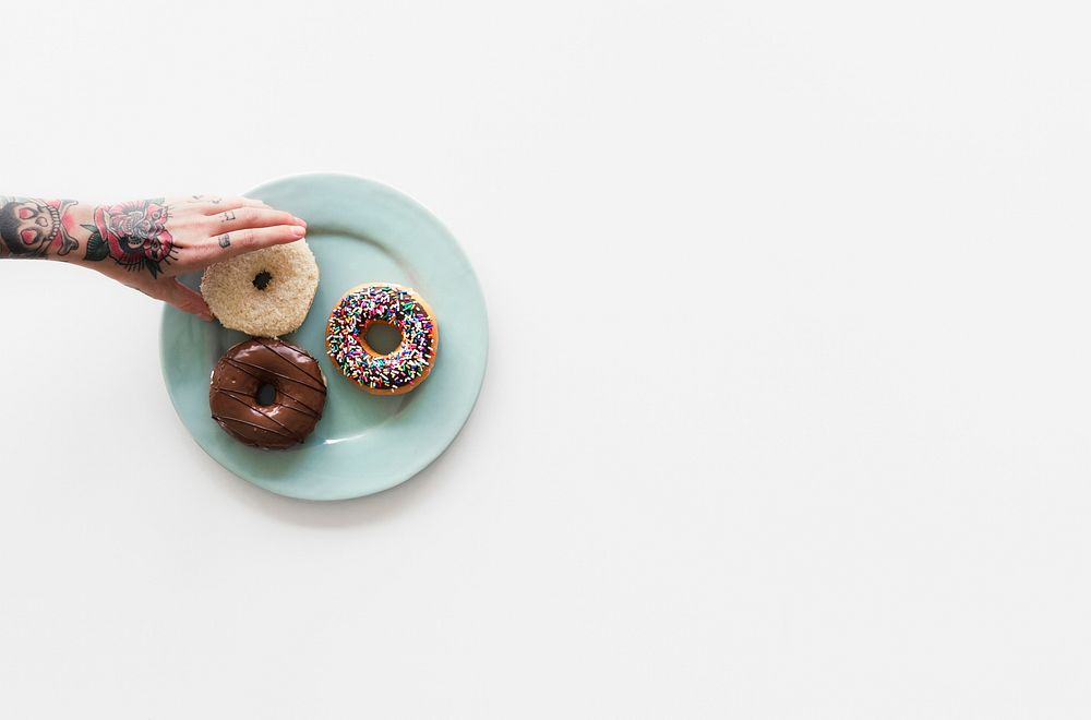 People Hands Reach for Doughnuts on the Plate