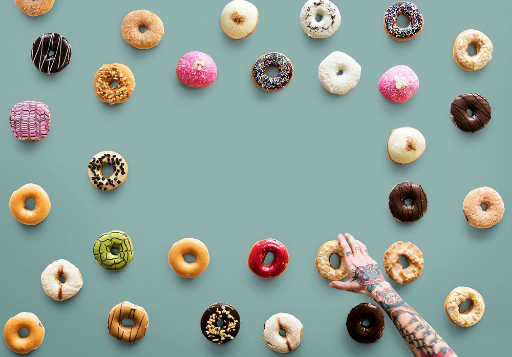 Hand with tattoo reaching for donut