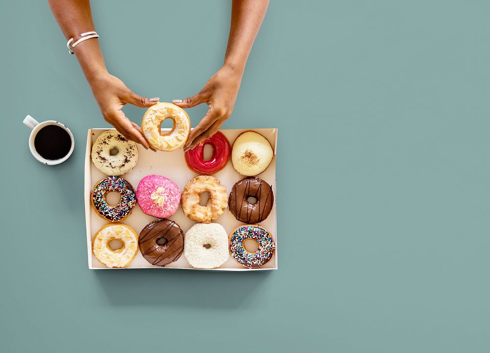 Hands holding sweeten donut dessert in aerial view