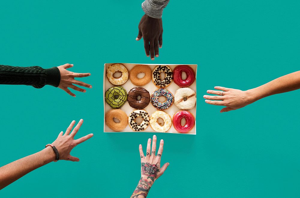Group of hands reaching sweeten donut dessert