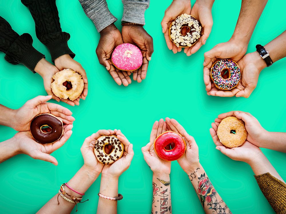 Circle of hands holding donuts