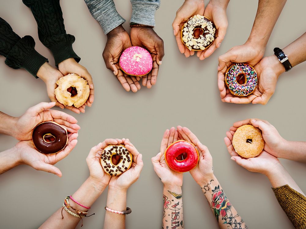 Circle of hands holding donuts