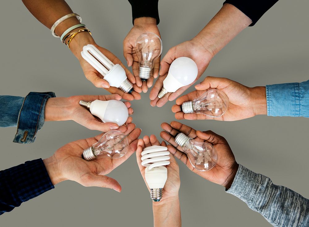 Circle of hands holding out different bulbs