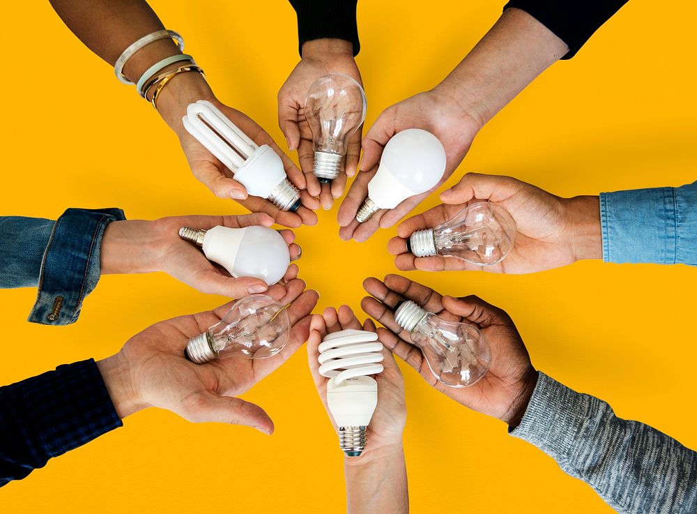 Circle of hands holding out different bulbs