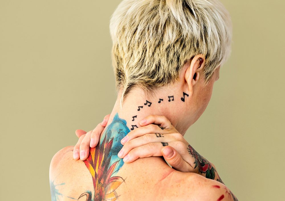 Portrait of a woman showing off her back tattoos