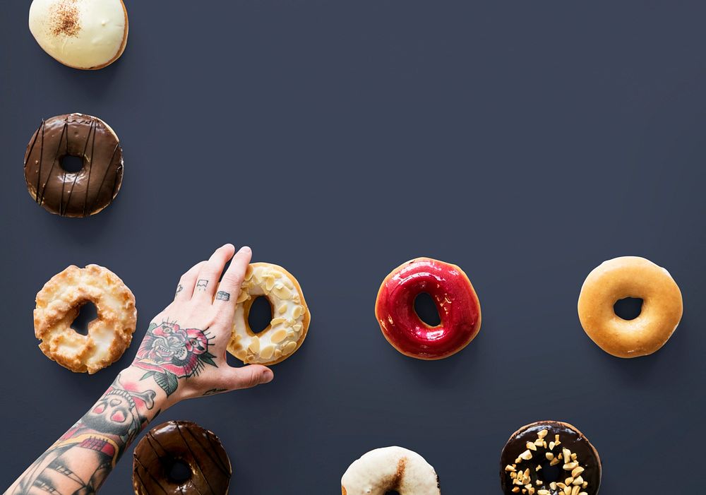 Hands selecting a variety of donut flavour