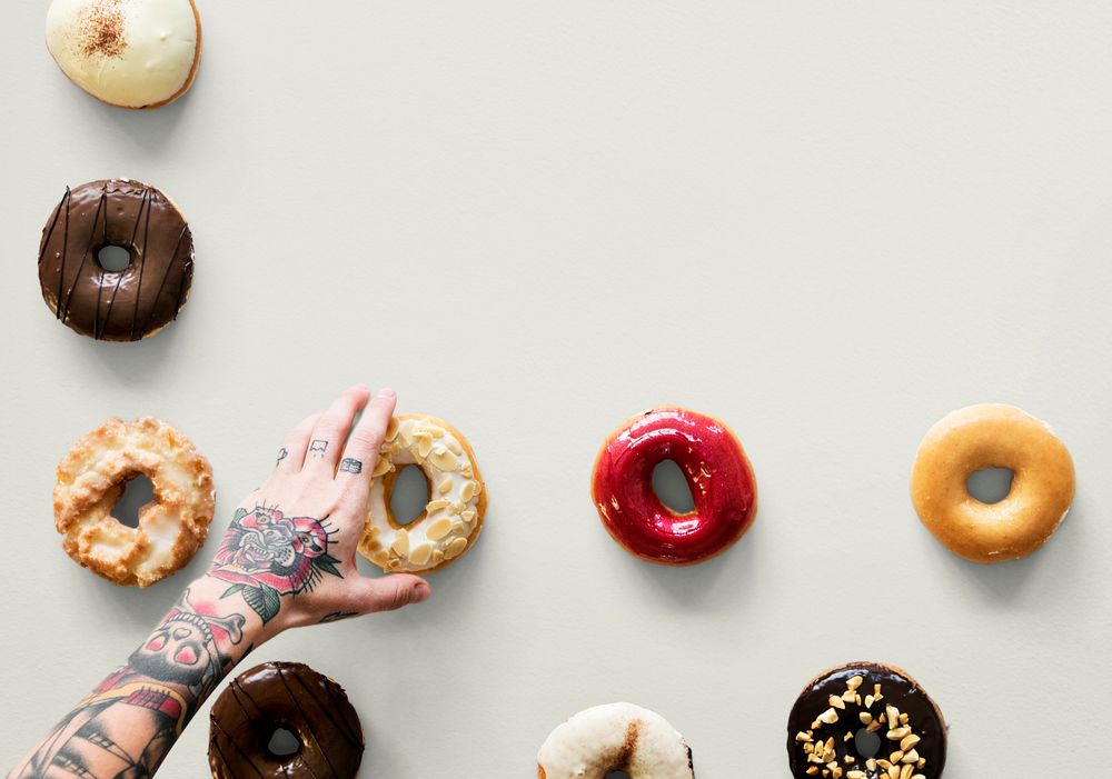 Hands selecting a variety of donut flavour