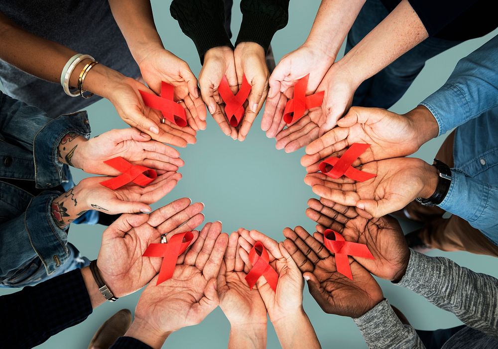 Group of hands holding red ribbon stop drugs and HIV/AIDS awareness