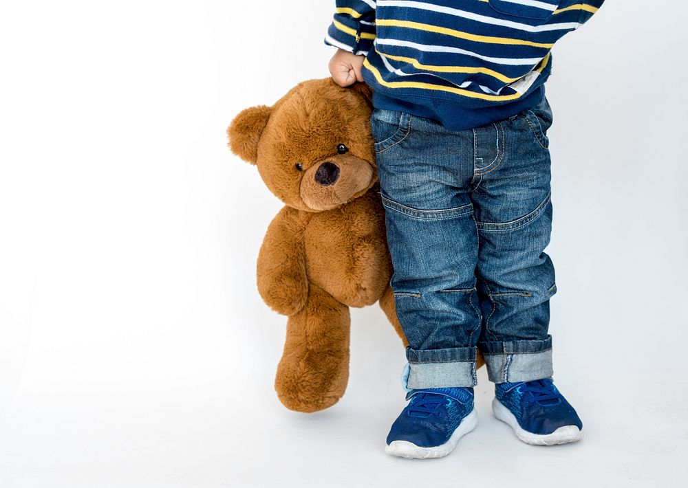 Young boy standing and holding teddy