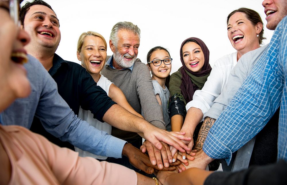 People joining hands together and smiling