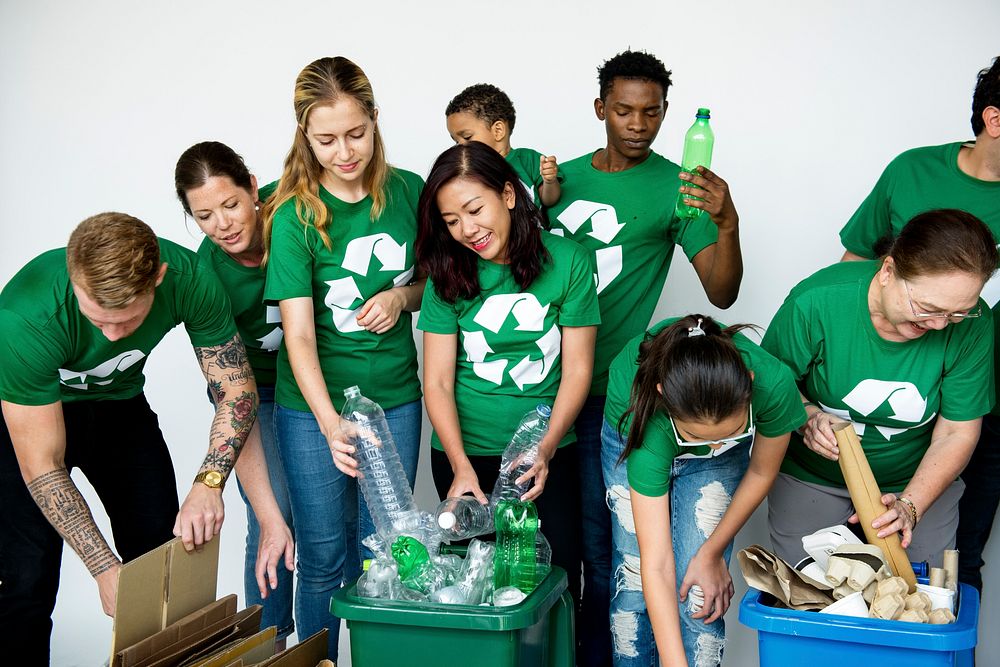 People in group helping together to put up bottles for recycle