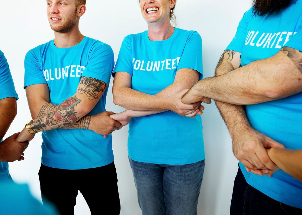 Group of volunteer people smiling and holding hand together