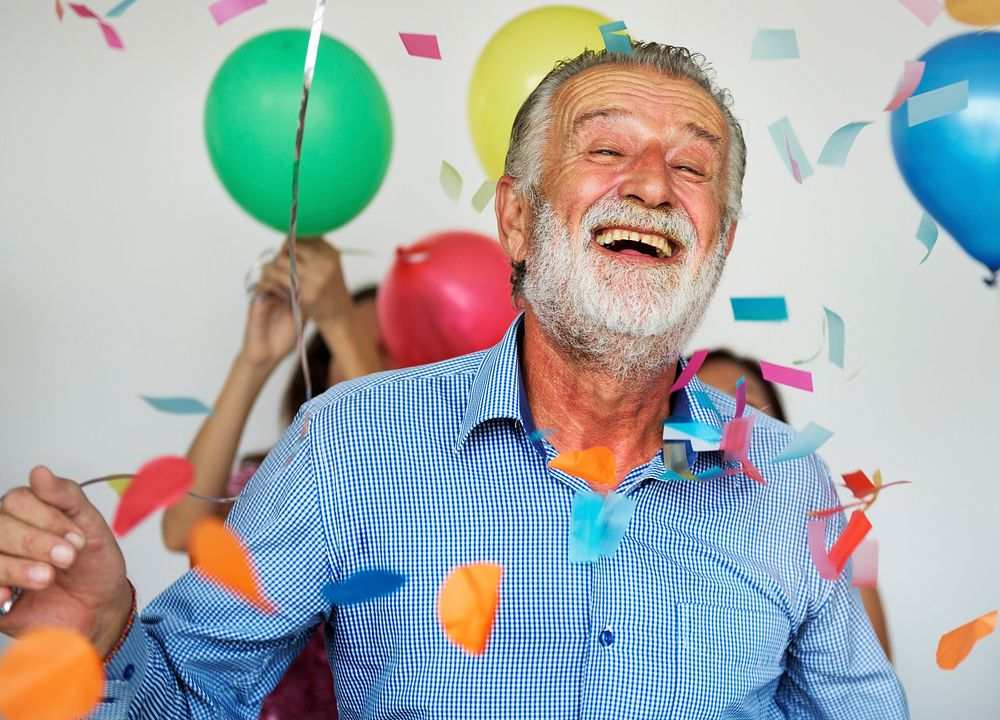 Happy senior man in admidst group of people in a party vibe