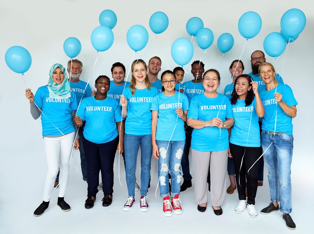 Group of volunteer people smiling and holding balloons