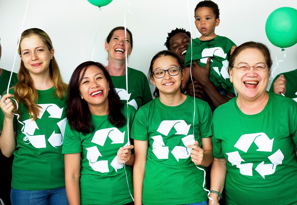 People in group wearing recycle icon shirts and posing for photoshoot