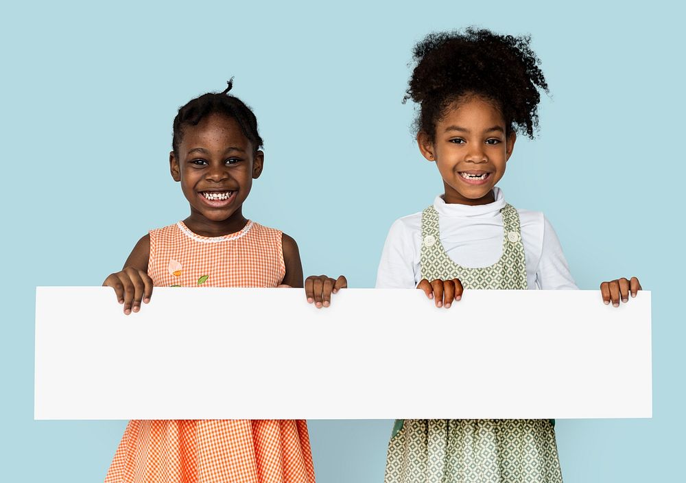 Cheerful little girls holding blank banner poster