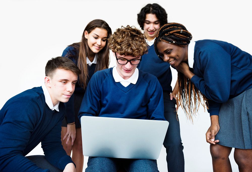 Group of students working as team on laptop