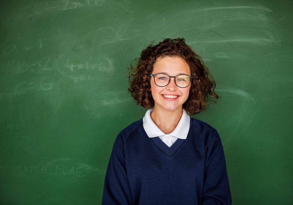 Young Student in Uniform with Chalk Board Background Portrait
