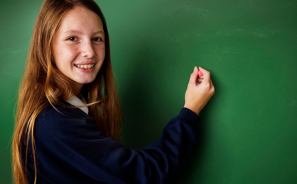 Teenage girls writing on whiteboard