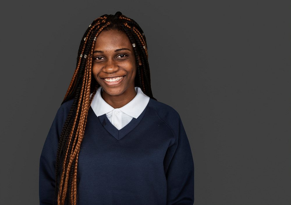 Portrait studio shoot of schoolgirl in uniform with smiling