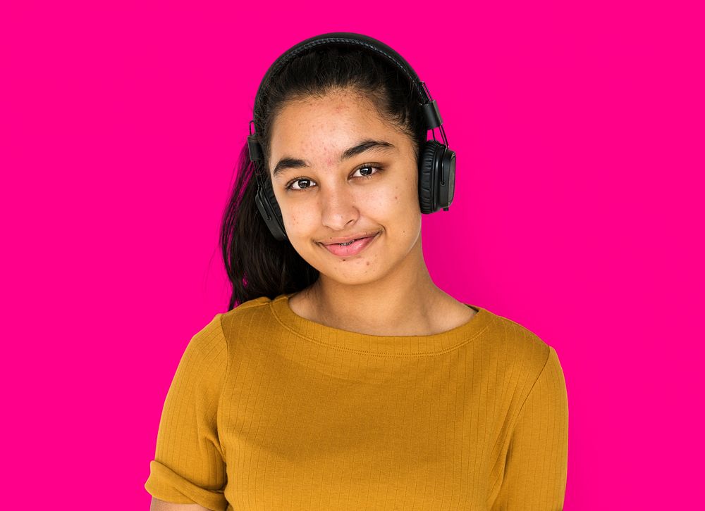 Indian girl smiling and listening music by headphones