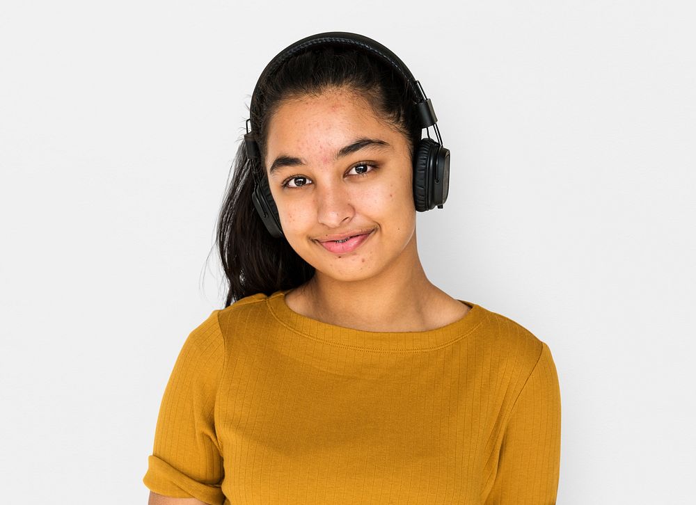 Indian girl smiling and listening music by headphones