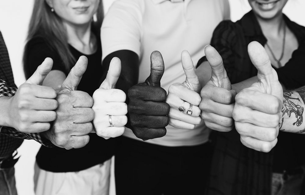 Group of people thumbs up together