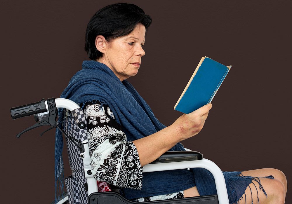 Disable Adult Woman Reading Book on Wheelchair Studio Portrait