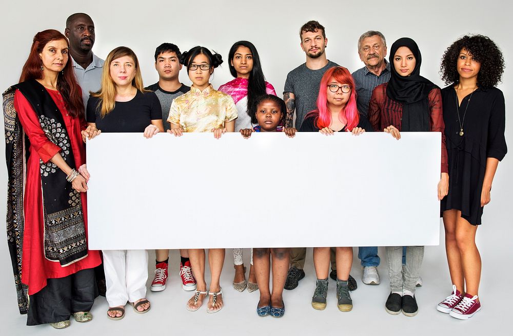 People standing in group for photoshoot holding banner