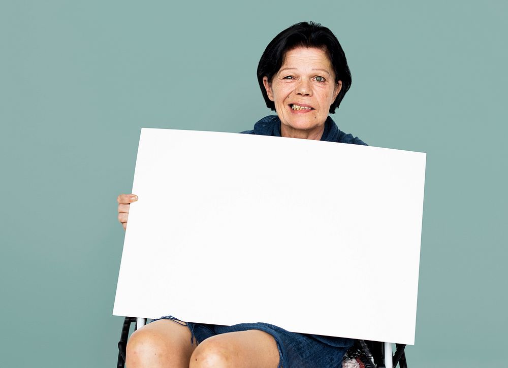 Senior adult woman on wheelchair holding blank banner