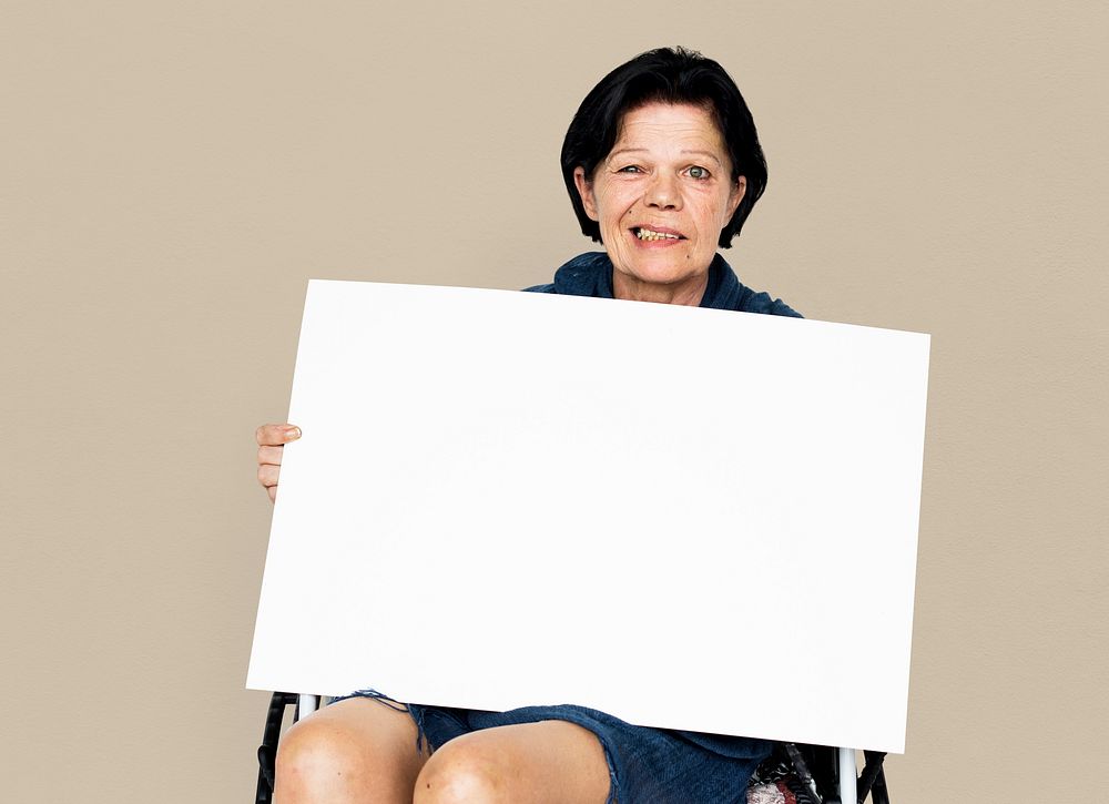 Senior adult woman on wheelchair holding blank banner