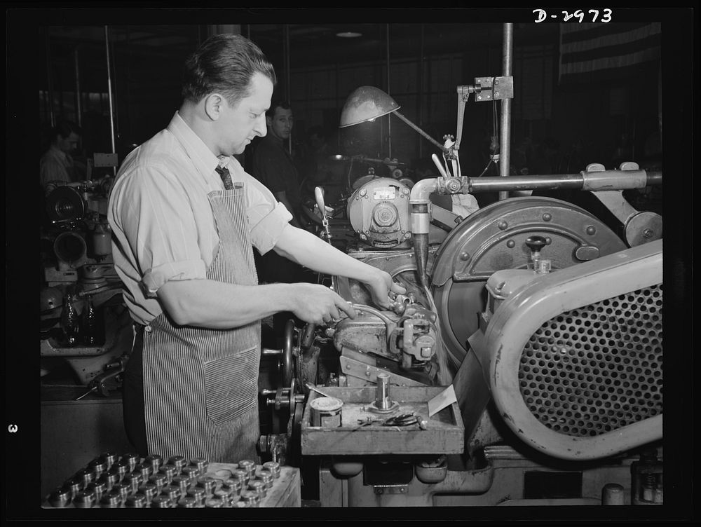 Conversion. Electric shaver plant. This worker in a New England plant that normally produces electric dry shavers is now…