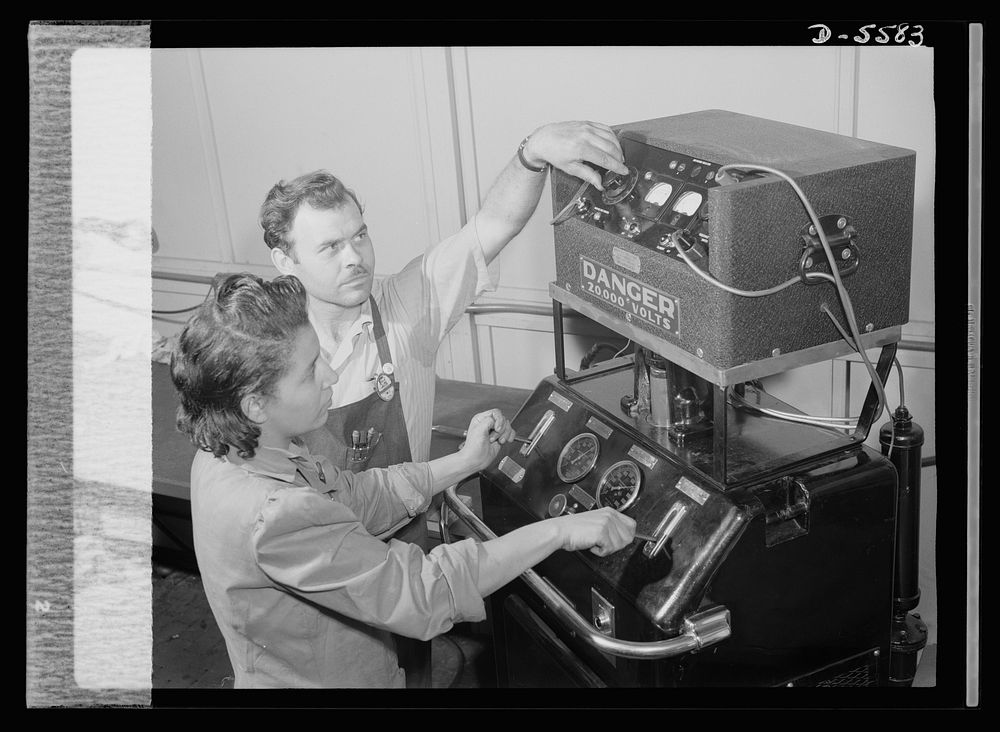 Production. Aircraft engines. Foreman F.I. Bowman shows Marietta Morgan how to operate this bomb-test machine used to test…